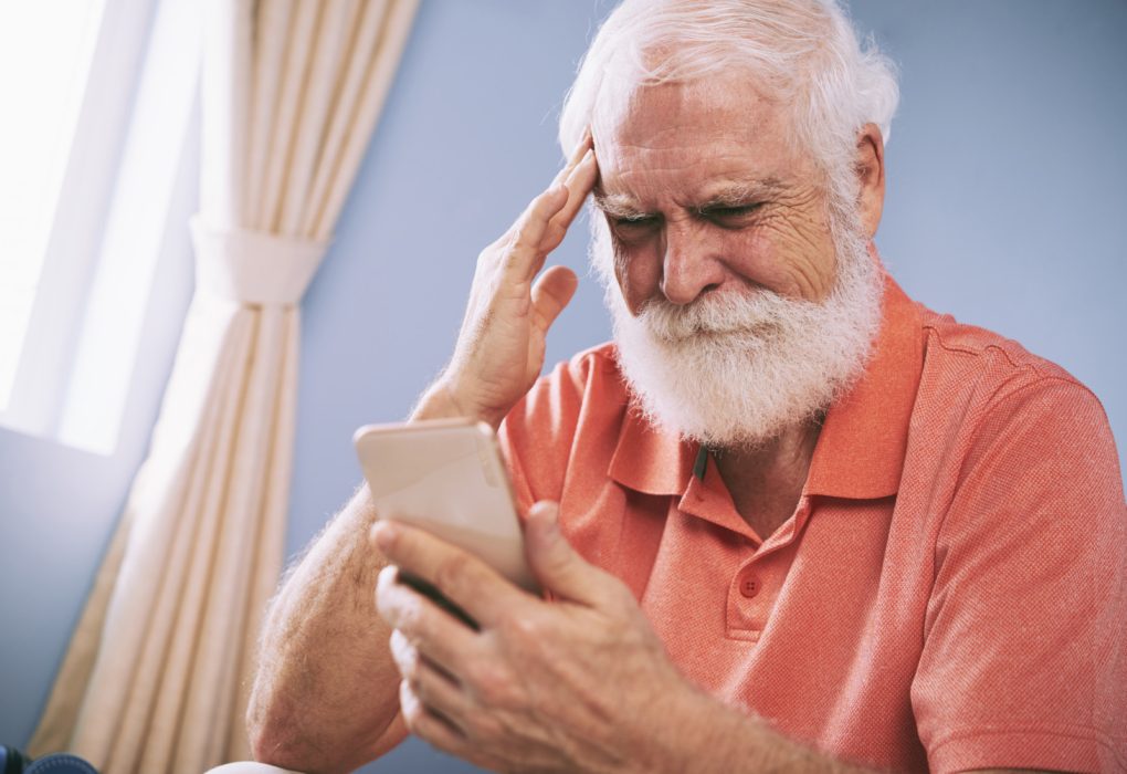 Medios de pago digitales y exclusión financiera: ¿Avance o nueva brecha social? Hombre mayor navegando en su teléfono móvil con dificultades.